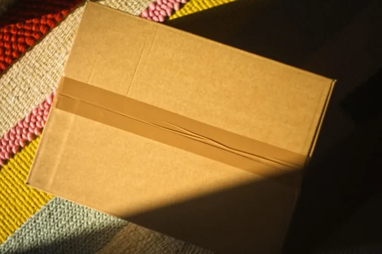 A cardboard box taped shut on a colorful rug