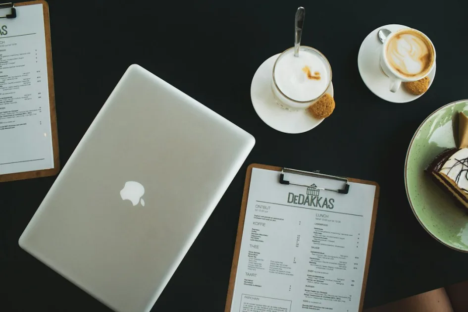 silver macbook beside white ceramic teacup on saucer